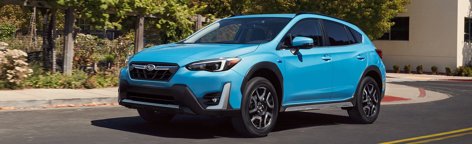 A 2023 Crosstrek Hybrid driving on a city street. | Jim Keras Subaru Hacks Cross in Memphis TN